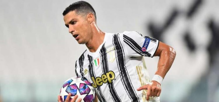 Cristiano Ronaldo pega na bola depois de cobrar um penalti no jogo entre Juventus e Lyon
