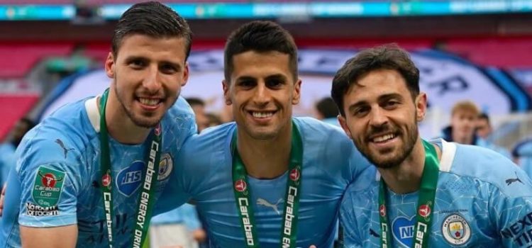 Rúben Dias, João Cancelo e Bernardo Silva após a conquista da Taça da Liga pelo Manchester City