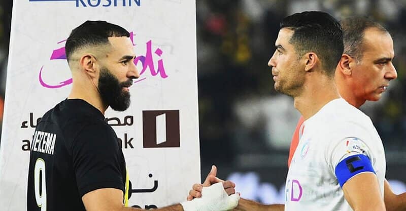 Cristiano Ronaldo e Karim Benzema cumprimentam-se antes do embate entre o Al Ittihad e o Al Nassr.